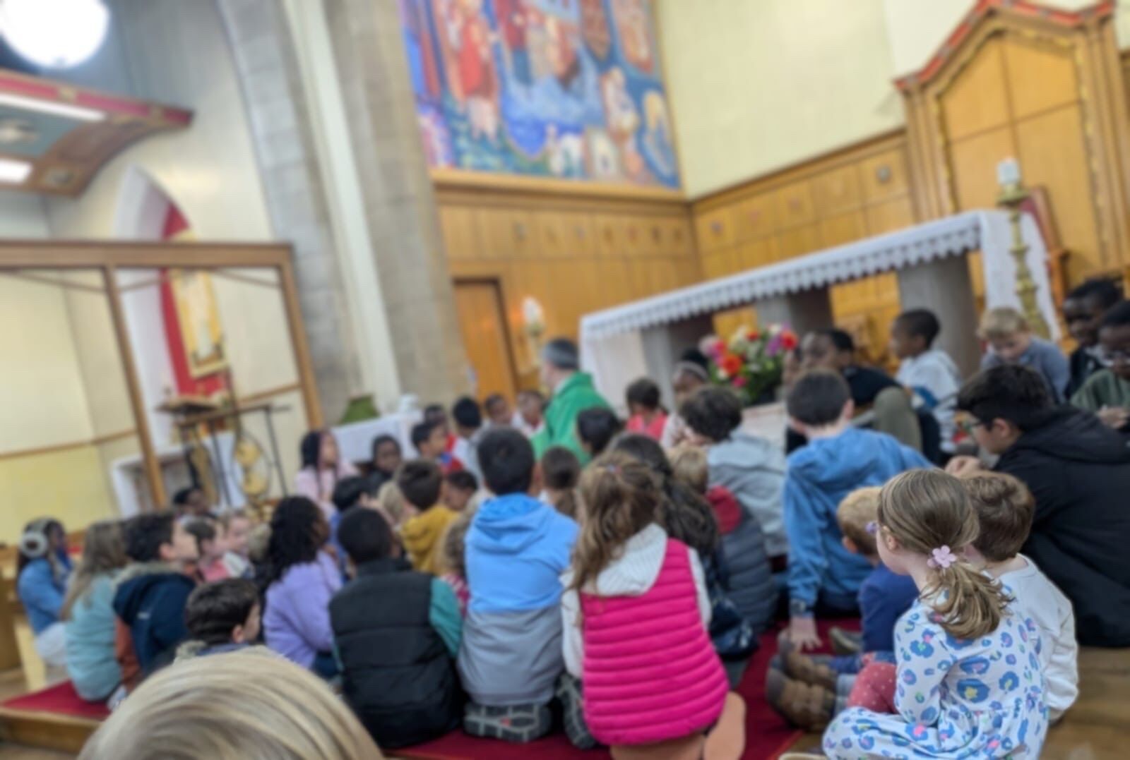 Fr Keith welcomes the young people onto the sanctuary in the monthly Children’s Mass